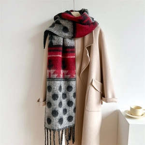 Detail of winter scarf showing red geometric patterns and black polka dots with fringe