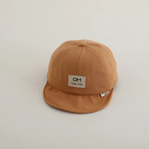 Detailed view of the soft caramel baby baseball cap showing breathable cotton texture