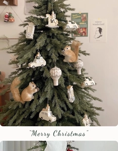 Detail of vintage cream squirrel figurine and white car ornament on a Christmas tree