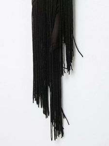 Detailed close-up of black satin fabric with elegant flowing fringe decorative tassels
