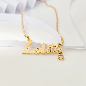 Macro detail of custom gold name necklace with Lolita script and purple birthstone charm