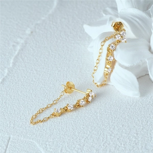 Detail of S925 sterling silver gold chain earrings with sparkling white zircon stones