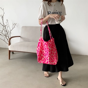 Pink leopard print canvas tote bag styled with casual outfit in a minimalist room