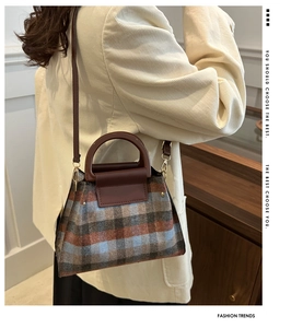 Détail du sac à main en laine à carreaux avec finitions en cuir brun et bandoulière