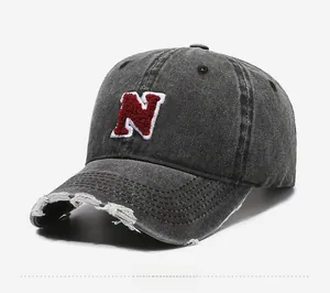 Detailed side view of vintage washed denim baseball cap with red towel-embroidered N letter