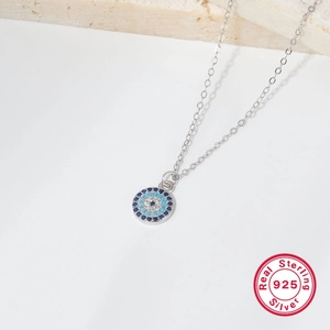 925 sterling silver evil eye necklace with blue stones on a minimalist background