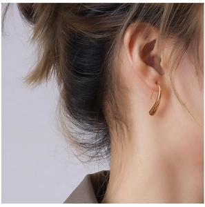 Close-up of elegant 18K gold plated teardrop hook earrings worn on a female model