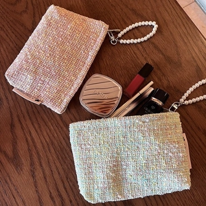 Tweed cosmetic bag with pearl handle strap and zipper closure in pink and blue colors