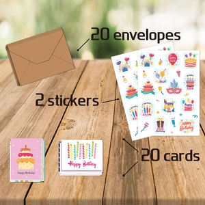 Vue à plat de 20 cartes d'anniversaire avec enveloppes et autocollants sur table bois