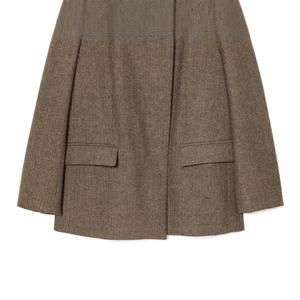 Detailed view of women's brown herringbone tweed blazer showing pockets and texture