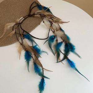 Detail eines böhmischen Haarbandes mit blauen Federn und Holzperlen auf gewebter Kordel