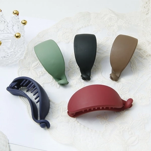 Detailed close-up of five matte finish banana clips in assorted colors on lace background