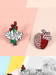 Detail of anatomical heart and brain enamel pins with tulip floral artistic design