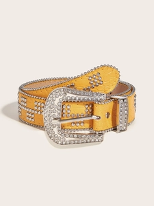 Close-up of yellow crocodile texture leather belt with silver rhinestone buckle and studs