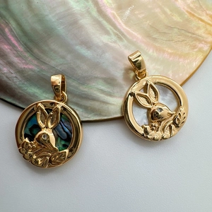 Close-up of 18K gold-plated rabbit charms with iridescent abalone shell inlay detail