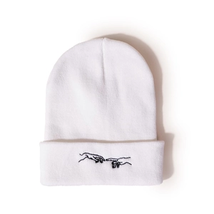 Détail du bonnet blanc en maille avec broderie noire de mains se touchant style art