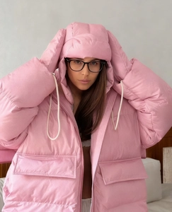 Close-up of pink oversized hooded puffer jacket with quilted texture and soft volume
