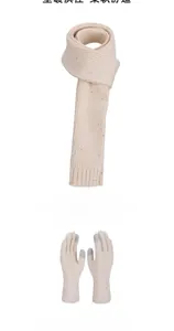 Detail of cream cable knit scarf and touchscreen gloves with subtle colorful flecks