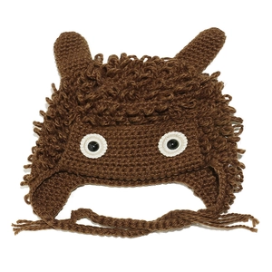 Detail of handmade crochet winter beanie with cute monster ears and soft braided straps