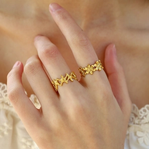 Golden starfish and flower stacking rings set on hand for summer ocean style jewelry