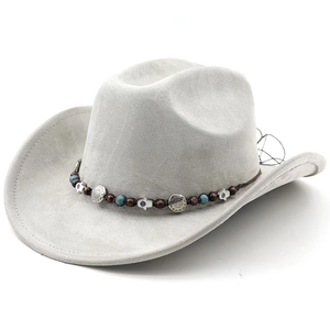 Détail d'un chapeau de cowboy gris clair avec bandeau ethnique perlé et breloques