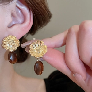 Vintage gold flower earrings with amber resin water drop charms shown on a model