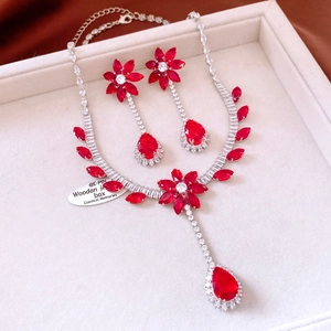 Close-up of zircon flower jewelry set with red stones in a white gift box