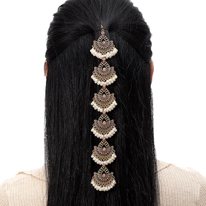 Detail of vintage gold head chain with pink gems and white pearls on hair