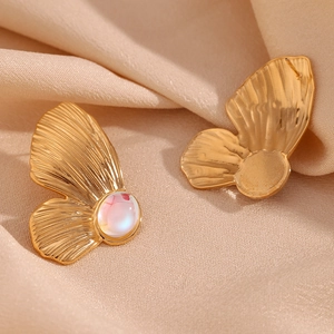 Macro view of matte 18K gold butterfly stud earrings with iridescent moonstone bead