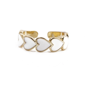 Detail view of the gold-plated adjustable ring featuring white enamel heart patterns