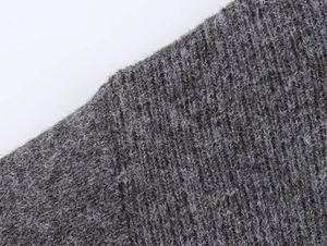 Primer plano de tejido de punto grueso gris oscuro que muestra fibras suaves en detalle