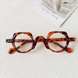 Close-up of tortoise shell glasses frame with unique wave bridge and silver metal rivets