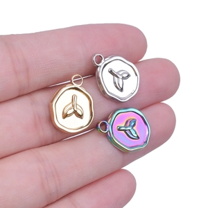 Three mermaid tail pendants in gold, silver, and rainbow steel for DIY jewelry making