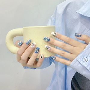 Blue and cream handmade press-on nails with 3D silver bows and rhinestone accents