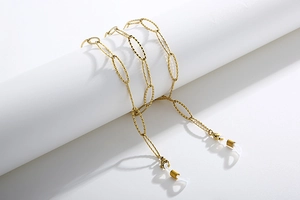Detailed view of golden textured link chain for glasses with white silicone loops