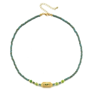 Retro turquoise beaded necklace with gold-plated evil eye pendant on white background