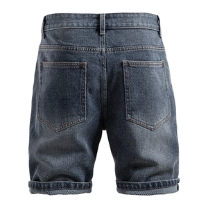 Rear view of vintage dark blue denim shorts featuring orange contrast stitching and cuffed hem