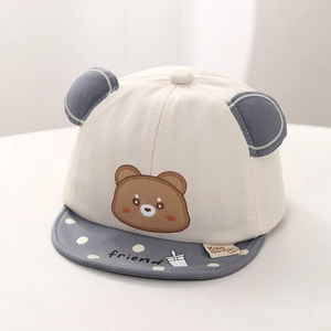 Close-up of baby baseball cap with bear embroidery, soft brim, and polka dot details