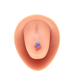 Detail of grape-shaped tongue piercing stud displayed on a silicone tongue model