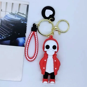 Close-up of a cartoon skull keychain in a red hoodie with a matching red patterned lanyard