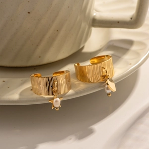 Detailed view of 18K gold star and heart charms on textured minimalist rings