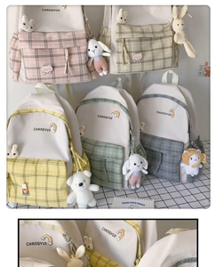 Detail of plaid canvas school backpacks with cute plush charms and rainbow embroidery