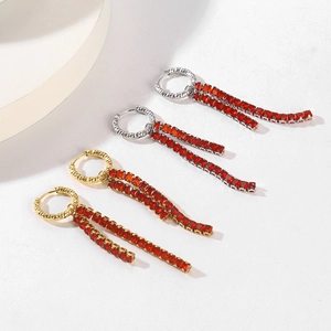 Detail of gold and silver tassel earrings featuring vibrant red rectangular zircon crystals