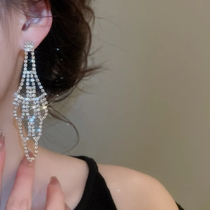 Close-up of sparkling long tassel earrings with rhinestones on silver-tone metal