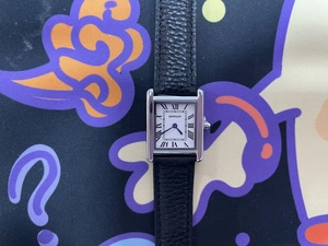 Detail of square silver watch case with white Roman dial and black leather strap