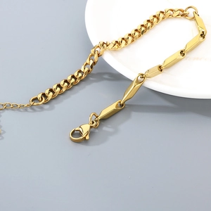Detailed macro view of gold-plated stainless steel Cuban link and geometric bar chain