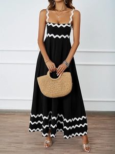 Detail of elegant black long sundress with white wavy trim and wooden straw bag