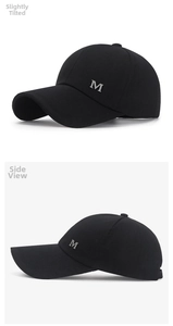 Detail view of the black canvas baseball cap featuring a silver metallic M logo on the side