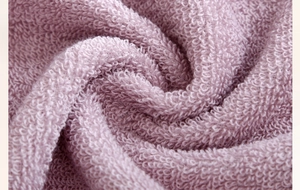 Detailed macro shot of soft lavender purple cotton bath towel showing loop texture