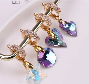 Macro shot of colorful crystal heart and star pendants with gold-plated rhinestone clasps
